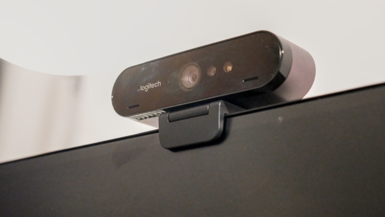 A webcam clipped to the top of a computer monitor, the hardware that decides what a video call sees before any virtual background is applied