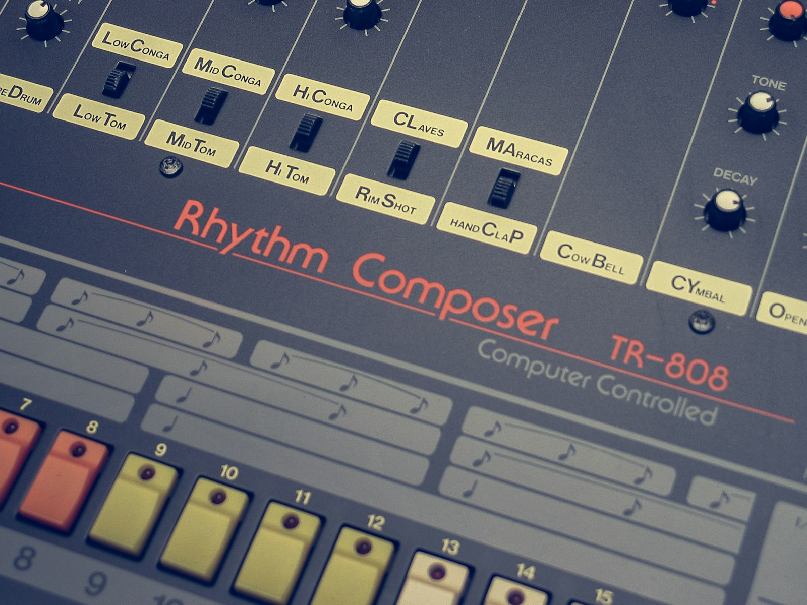 Close-up of a Roland TR-808 Rhythm Composer, the drum machine the trap 808 is named after, showing its step sequencer pads and labeled drum voices
